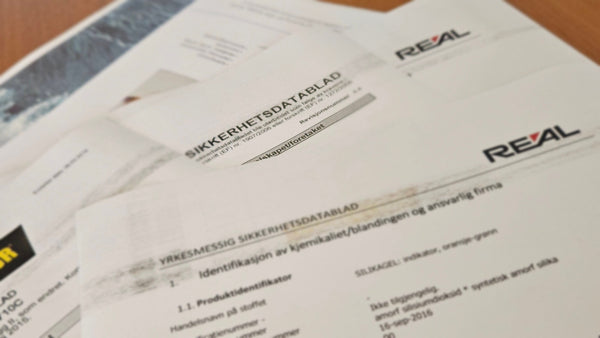 Säkerhetsdatablad och dokument från Reál Marine AS på kontorsbord, kemikalieskydd, offshore