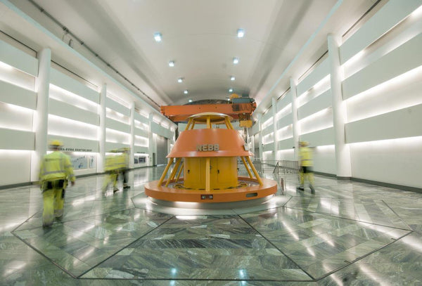 Industrihall med orange generator, NEBB, och arbetare i skyddskläder, Reál Marine