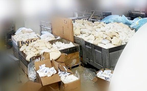 Stora metallcontainrar och kartonger fyllda med preserveringsprodukter hos Reál Marine AS